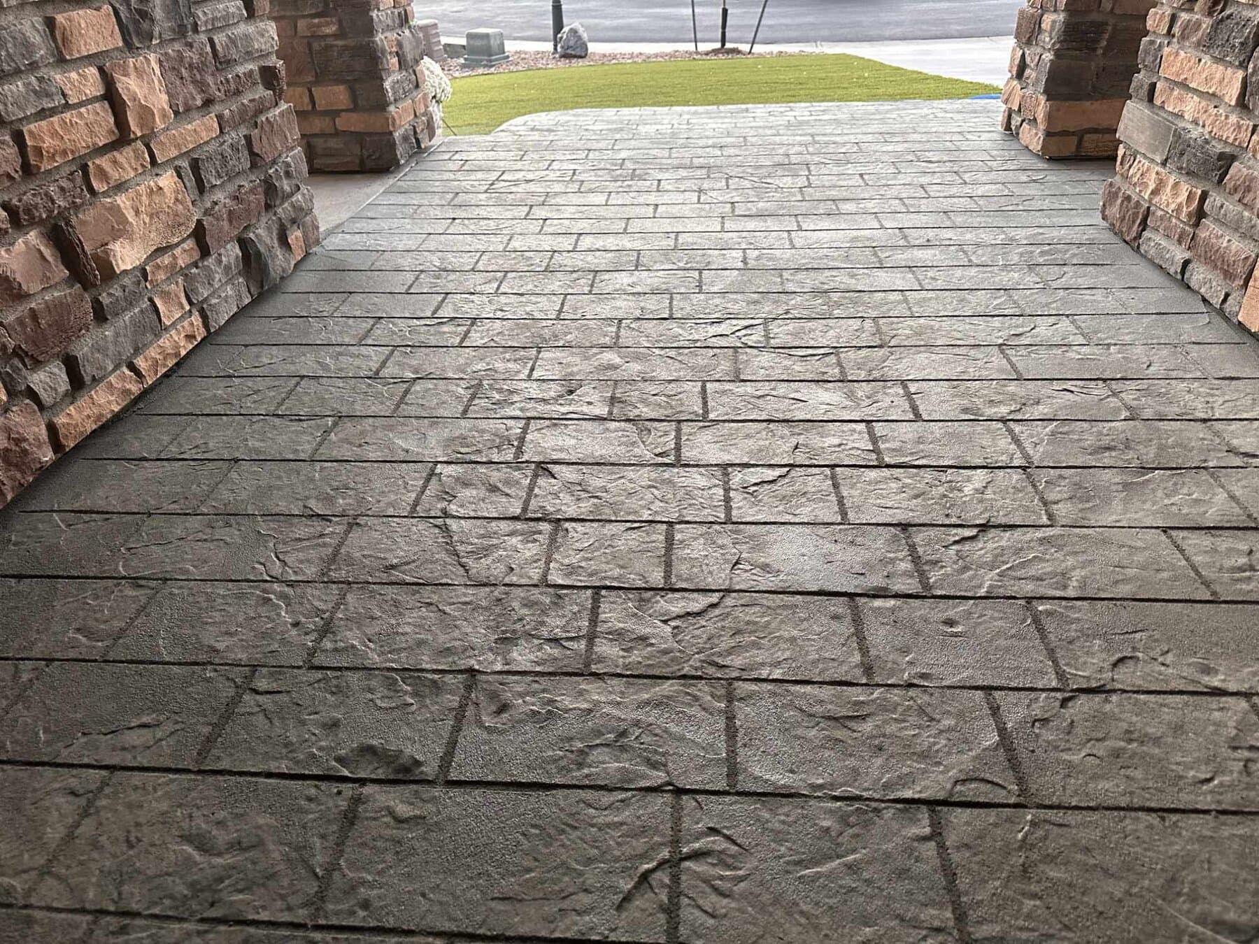 Ashlar slate stamped walkway framed by brick columns