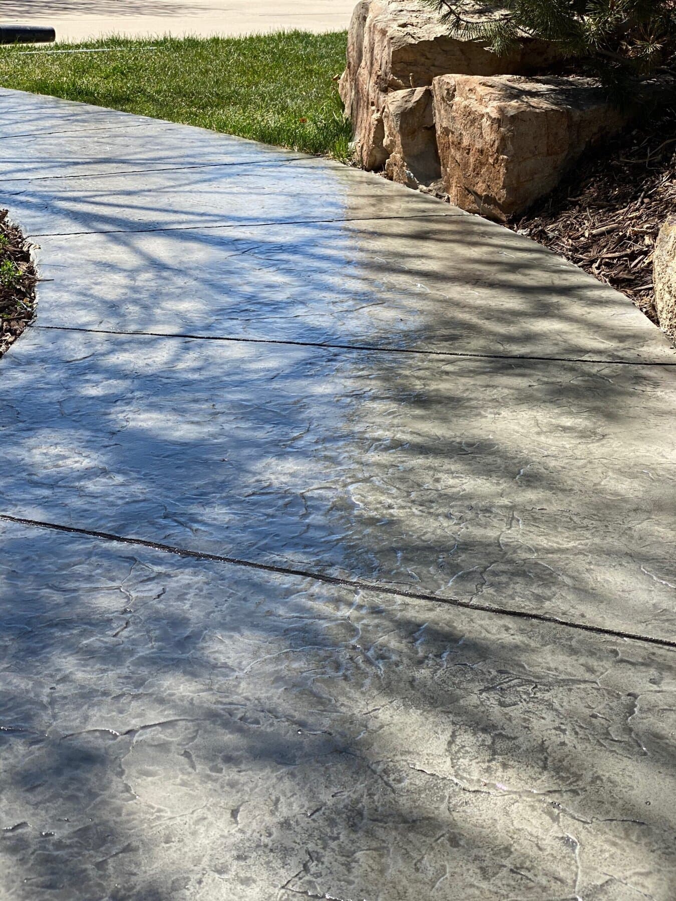 Slate-pattern walkway beside stone boulders